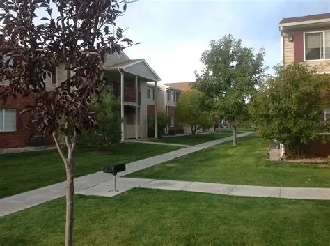 Apartment community with landscaped lawns, walkways, and mature trees